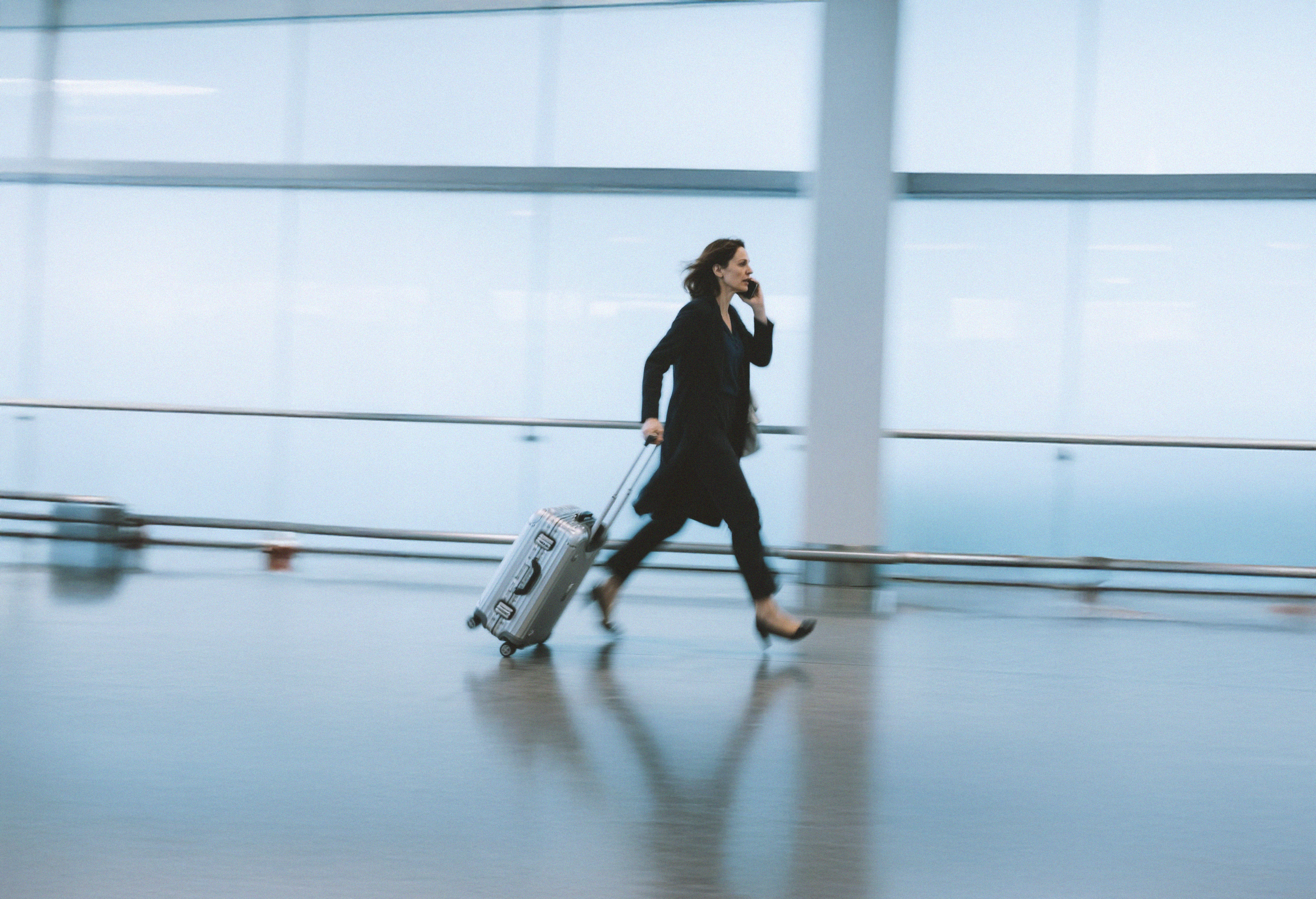 AI generated image: Business woman walking through airport terminal.