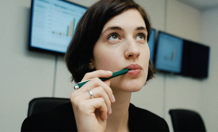 AI generated image: woman holding a pen in front of screens in a meeting room.